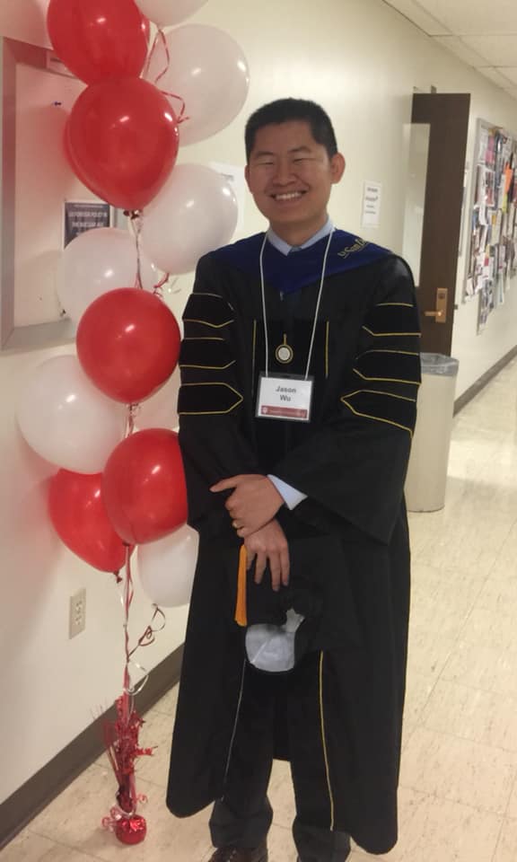 male student wearing black and gold graduation gown