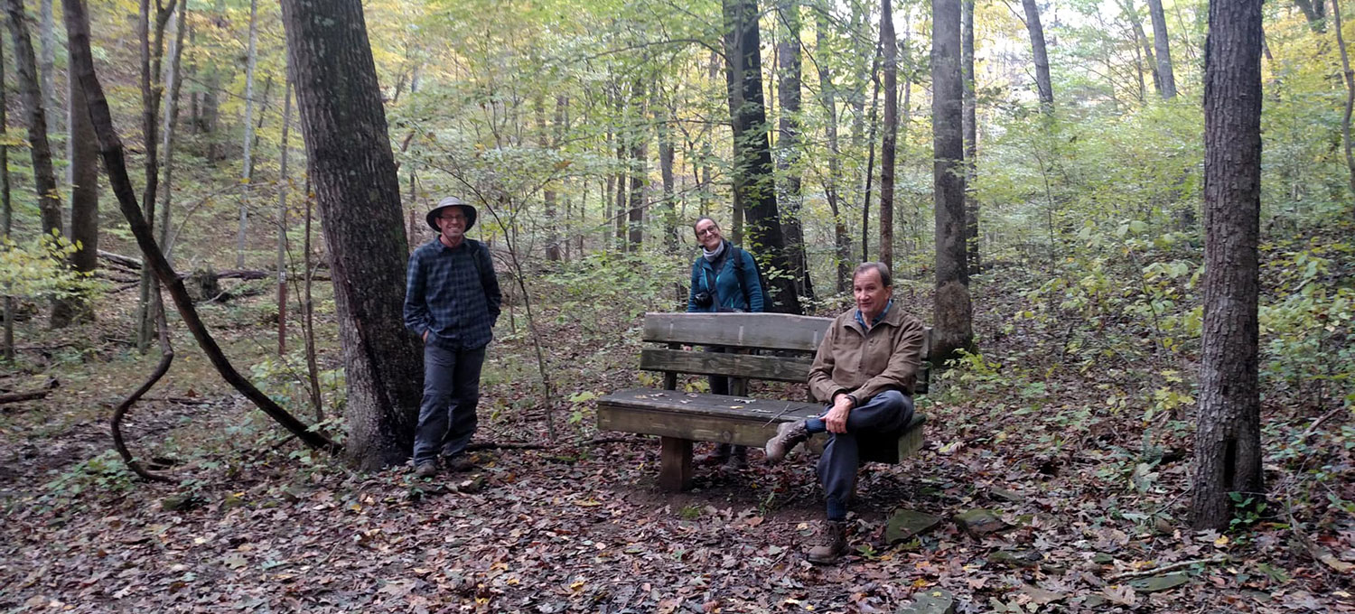 Three people pose together in Dunn Woods.